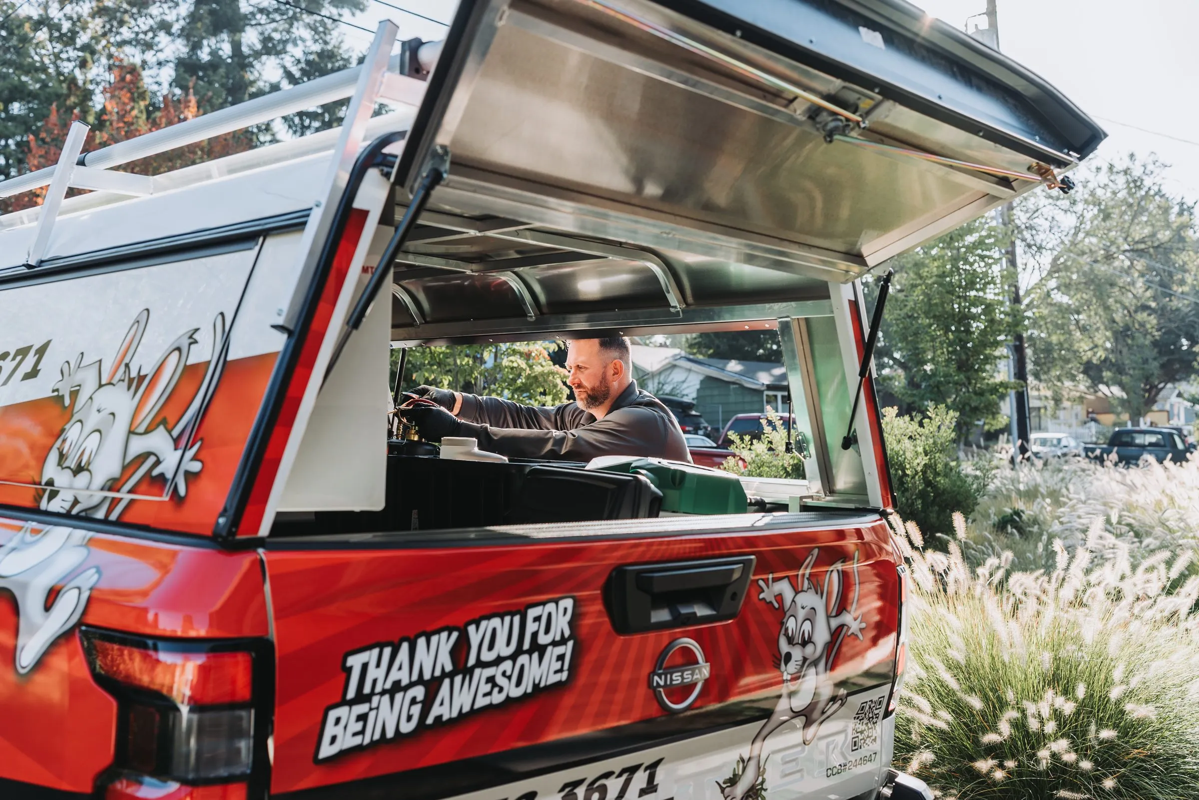 An A&A technician loading gear at the back of a service truck