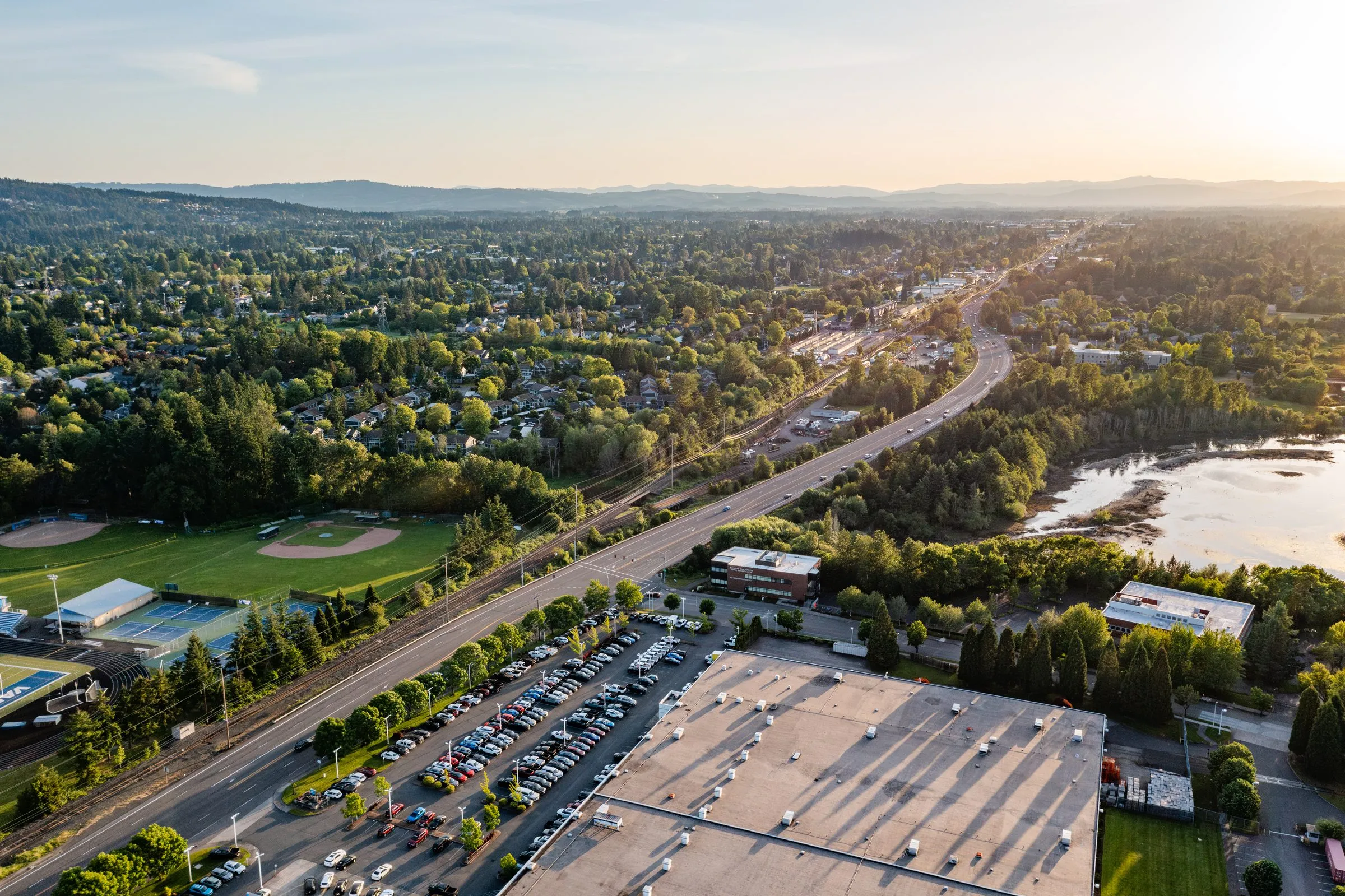 An aerial view of Beaverton, Oregon, with a highway running through town in the evening light