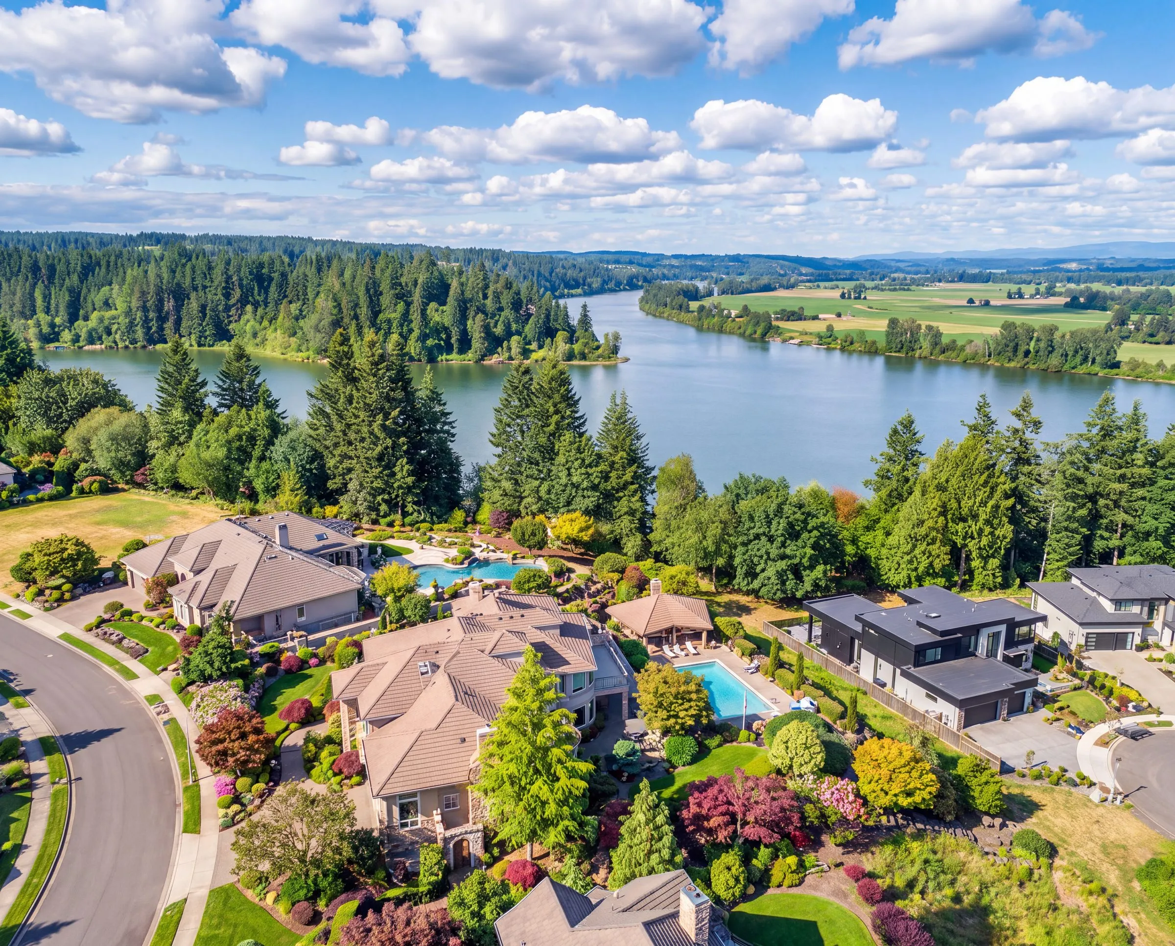 An aerial view of homes above a lake in Camas, Washington, with evergreens and farmland beyond