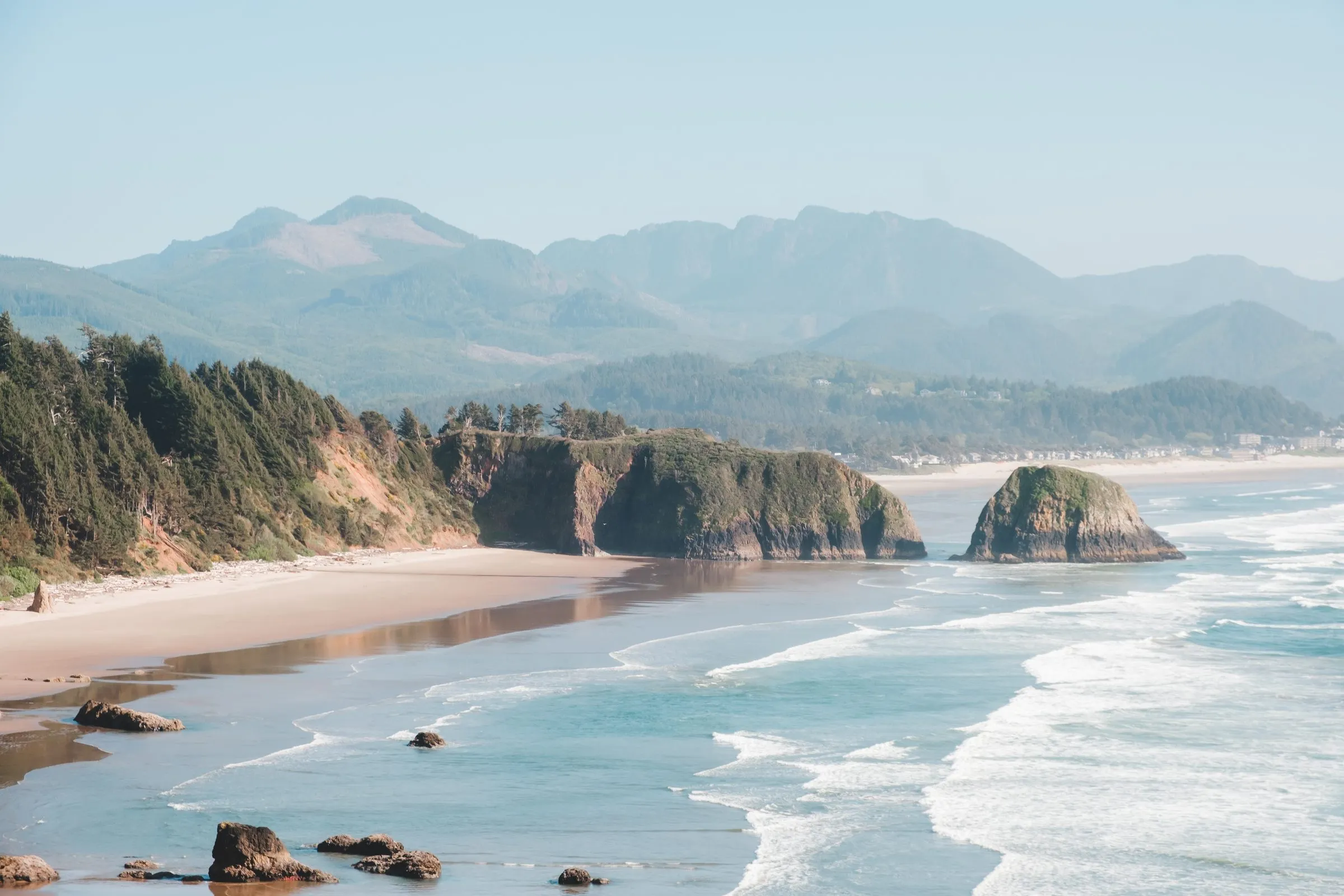 The coastline and sea stacks near Cannon Beach, Oregon, with waves rolling onto the beach