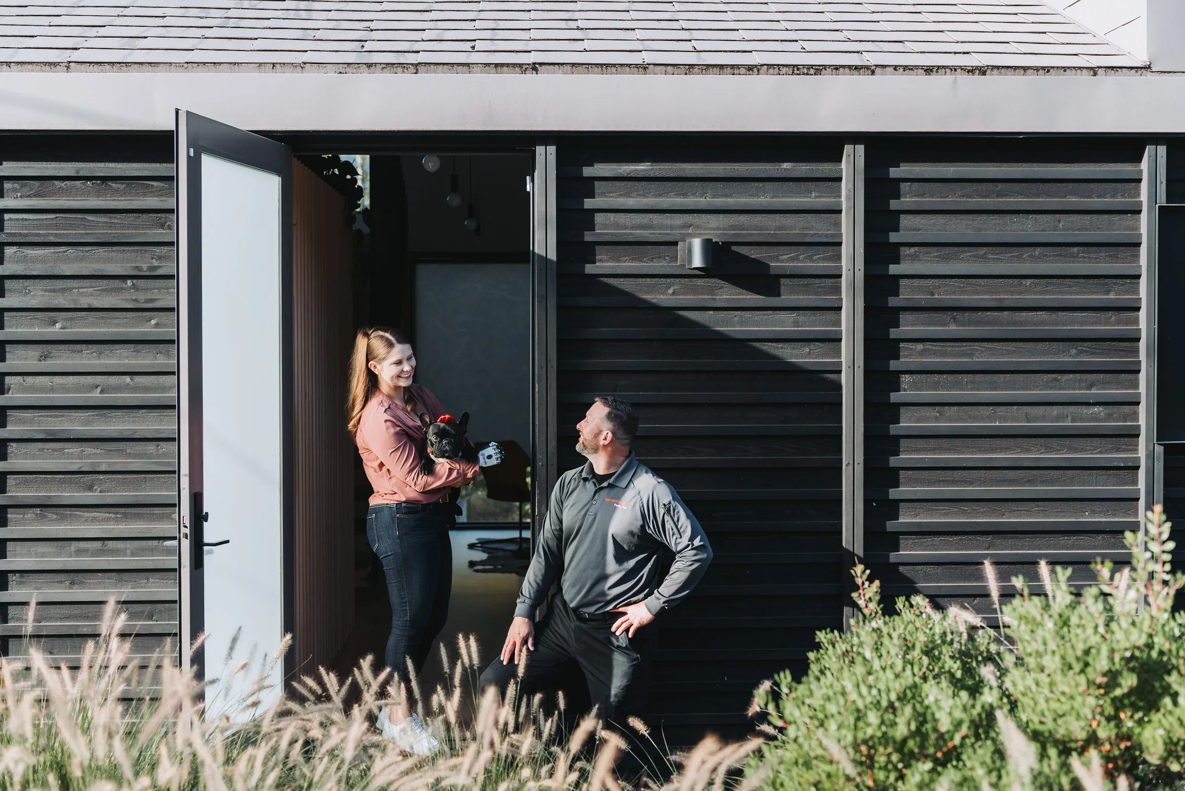 An A&A technician talking with a customer at her front door