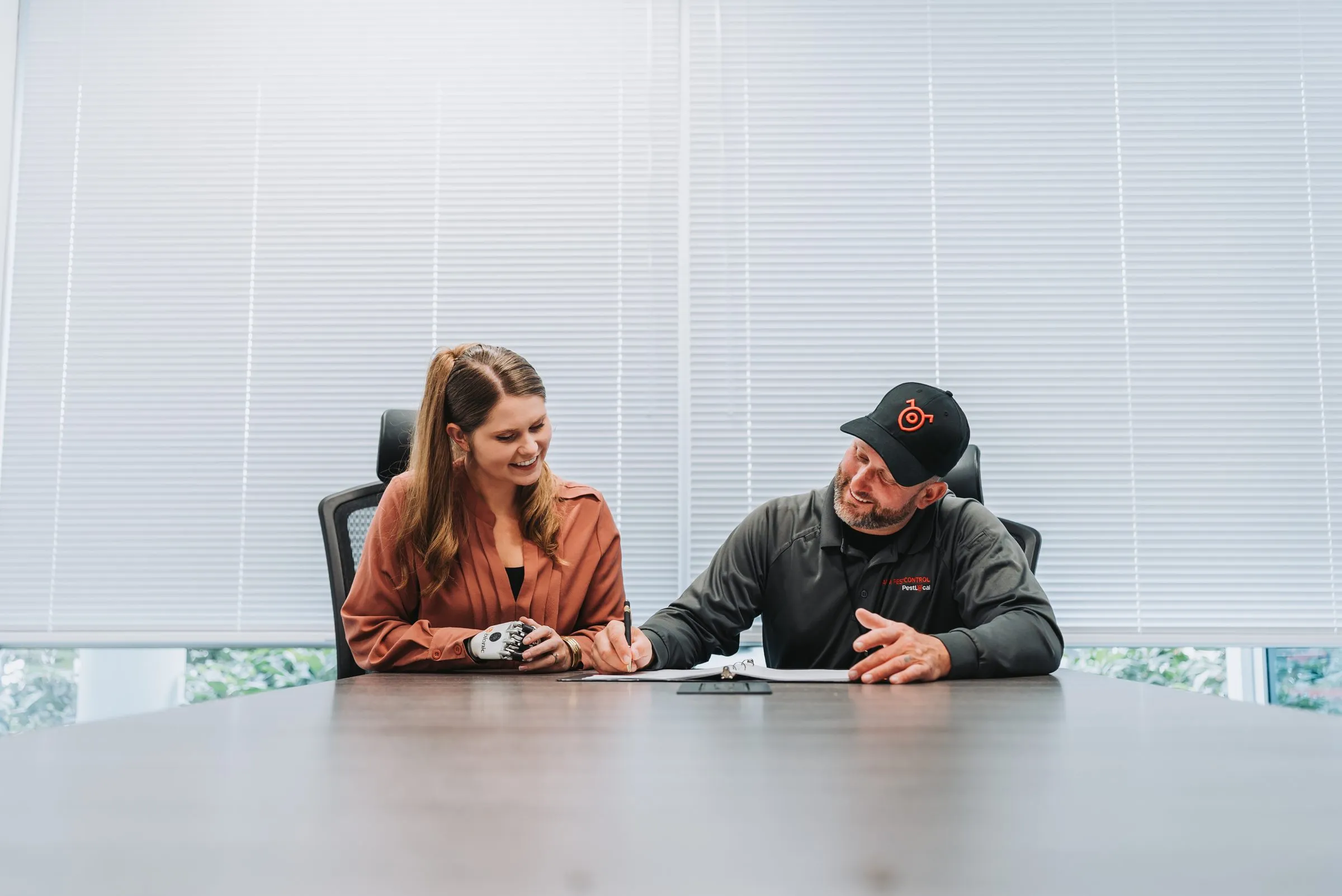 An A&amp;A technician and a customer going over a service agreement at a conference table
