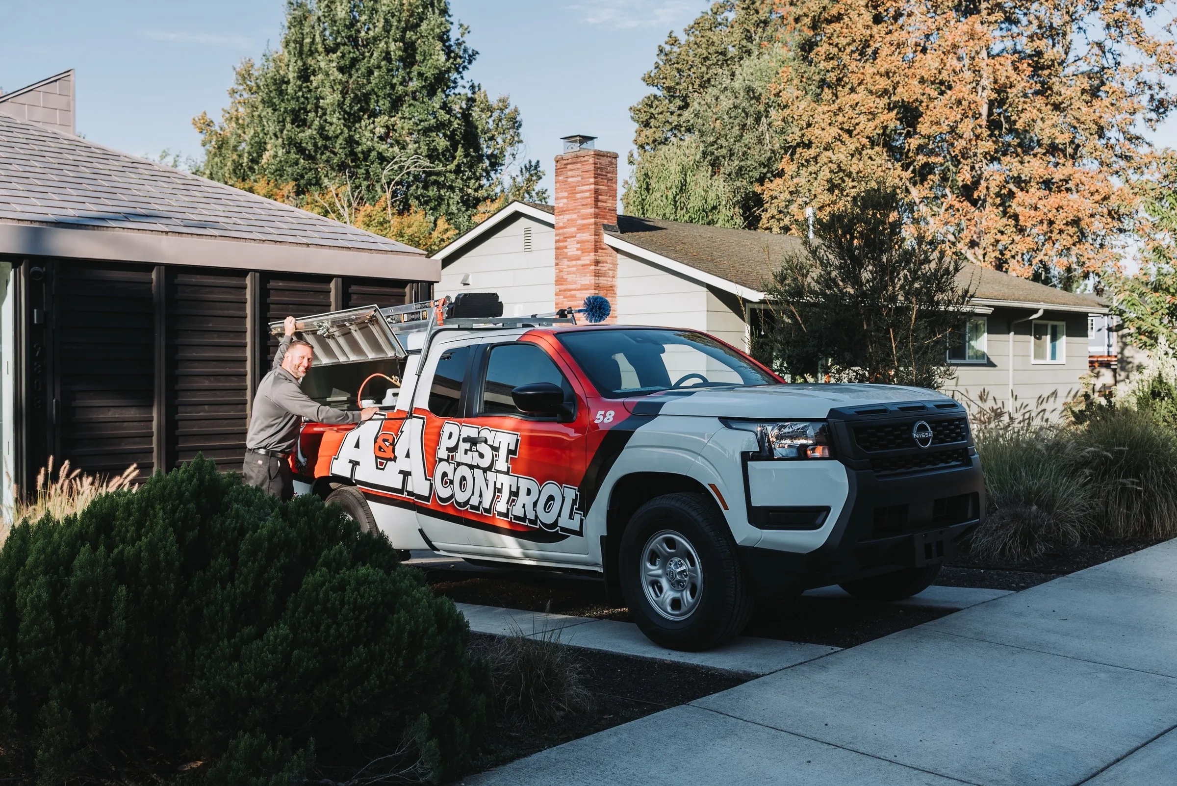 An A&A technician at the back of his service truck in a customer's driveway