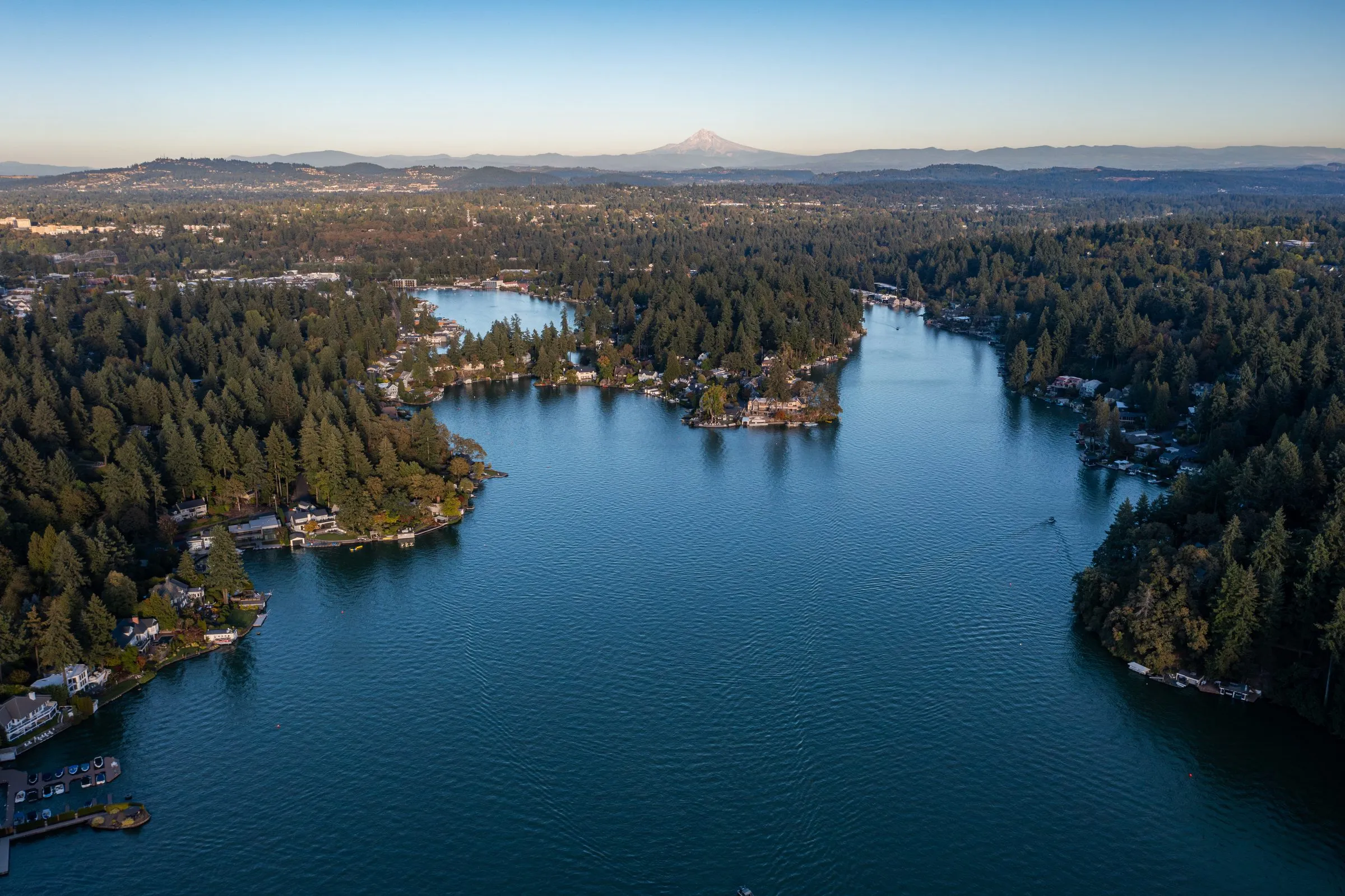 An aerial view of Oswego Lake in Lake Oswego, Oregon, with a mountain beyond