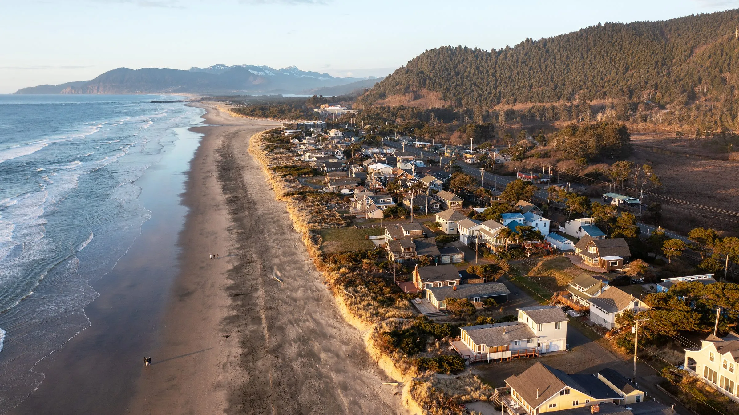 An aerial view of the beach and homes of Manzanita, Oregon, in the evening light