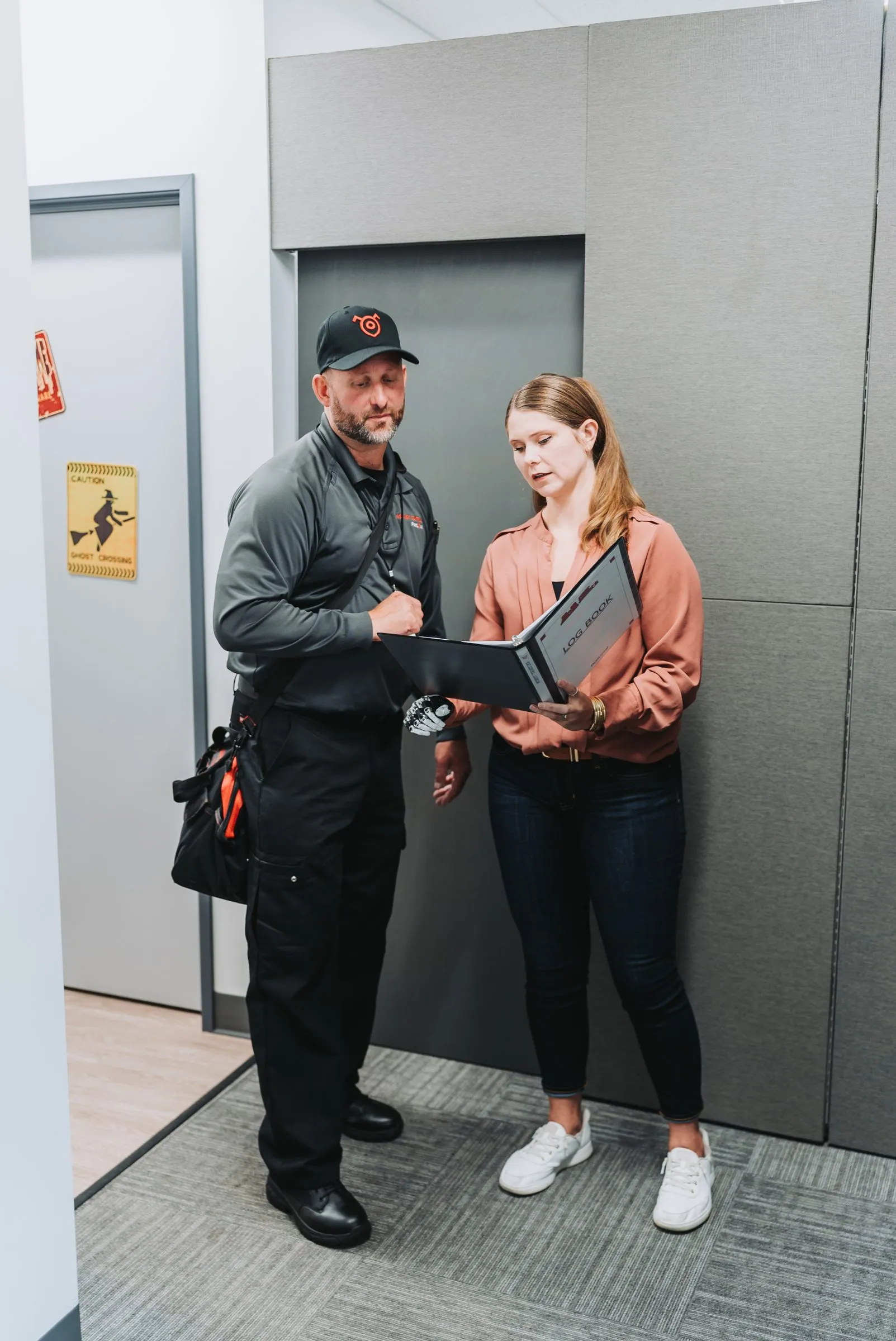 An A&A technician walking a facility manager through the service logbook