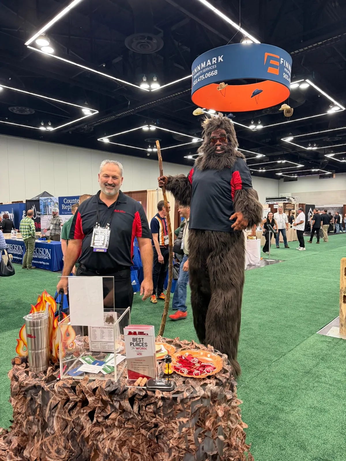 Owner Steve Wittig with Bigfoot, in an A&A shirt, at A&A's trade show booth