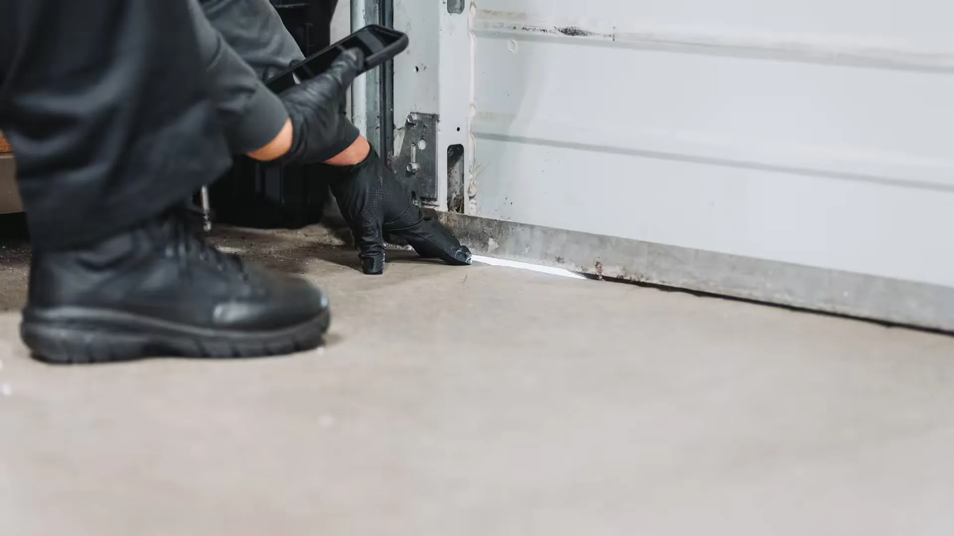 AA technician inspecting entry point in garage which stink bugs and boxelder bugs are entering from.
