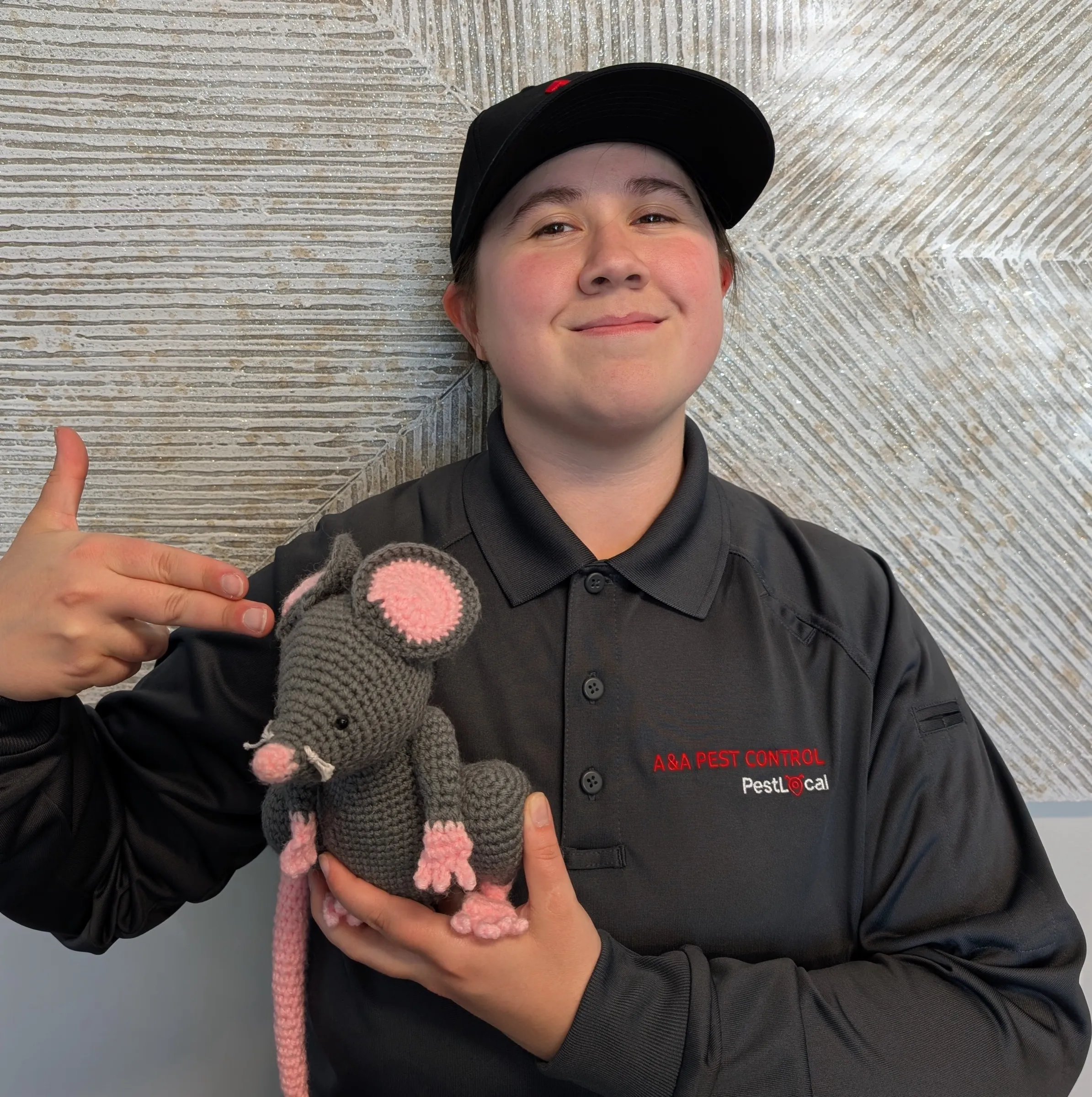 An A&A technician in a cap posing for a fun team portrait