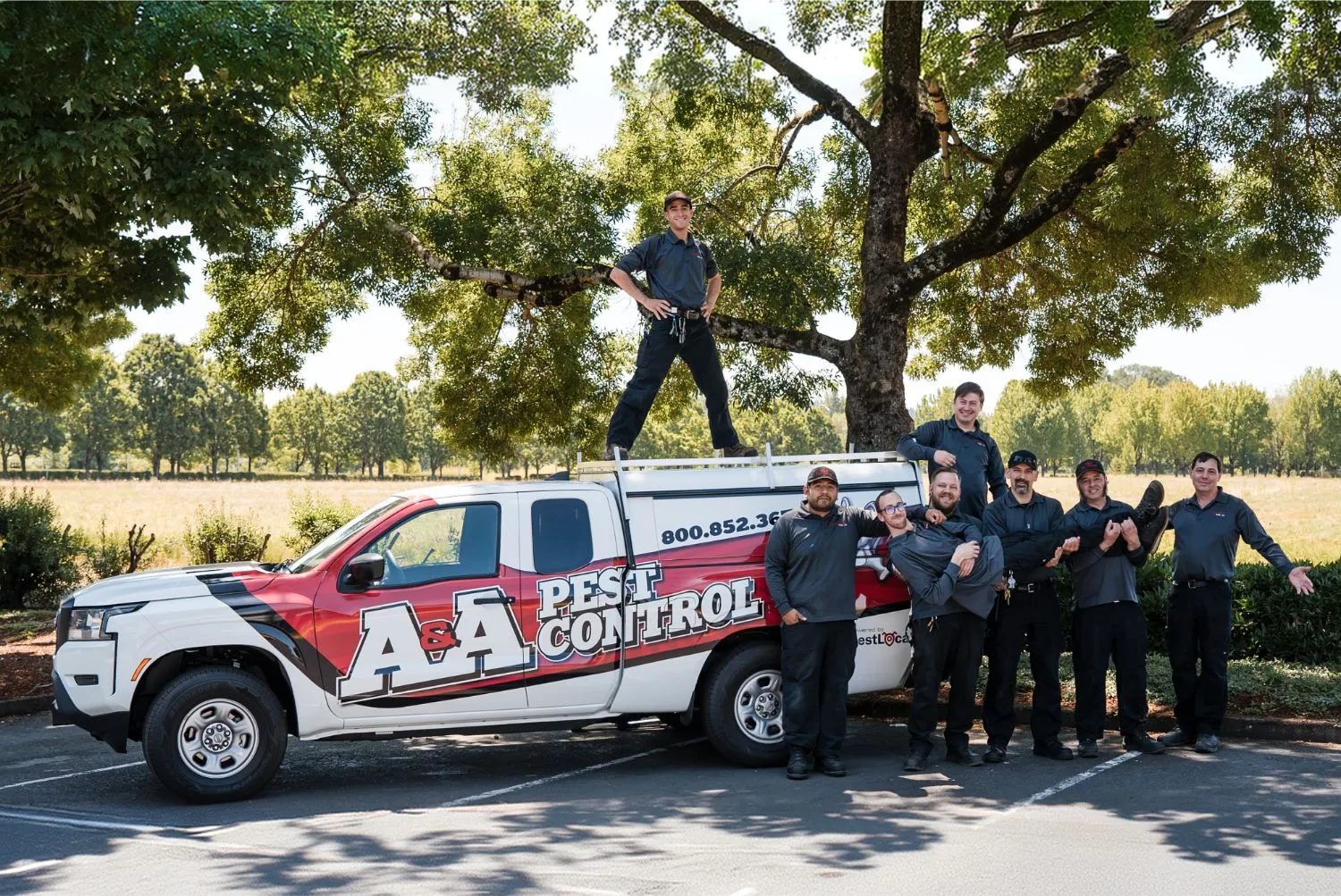 The A&A crew lined up in a field with their arms out wide