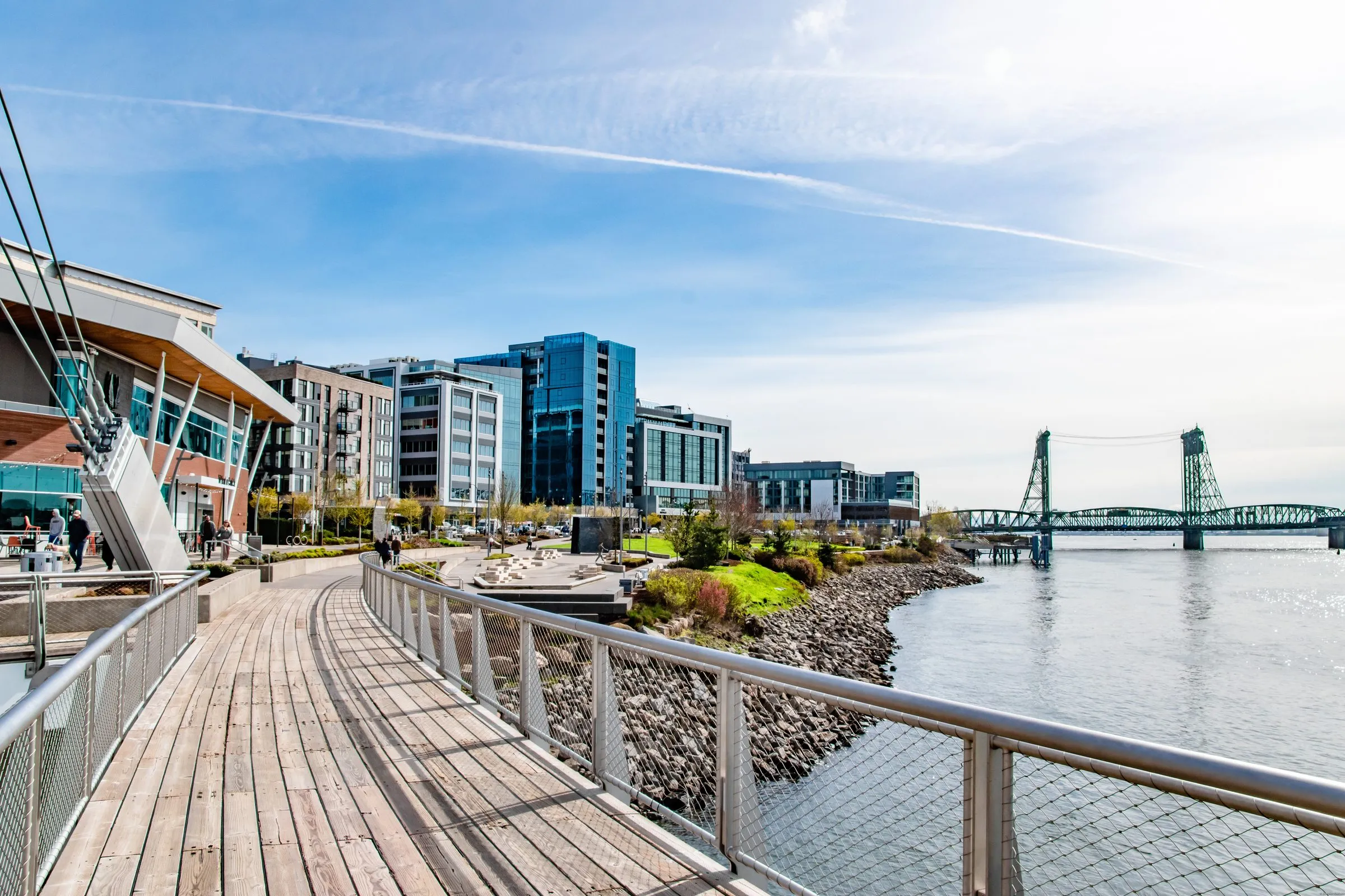 The boardwalk on the Vancouver, Washington waterfront, with new buildings and a bridge beyond